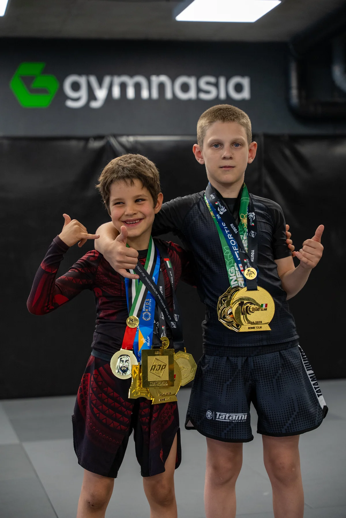 Young grapplers celebrating medals after camp competition